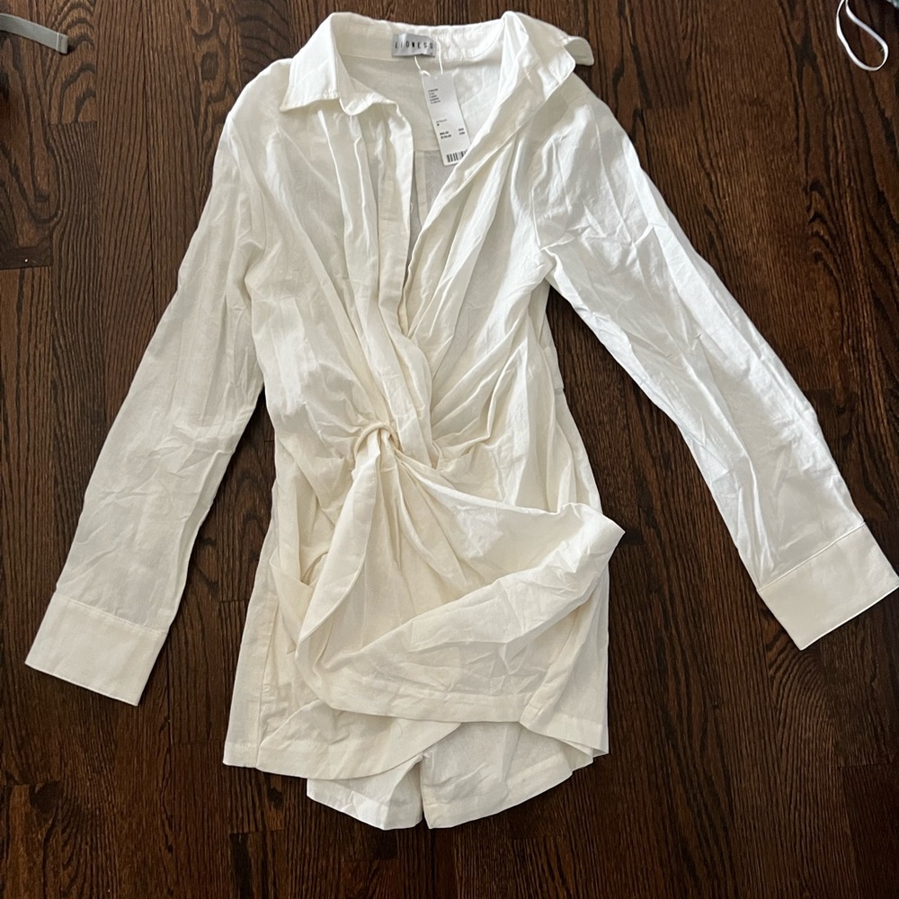White dress with plunging neckline and tie knot detail at waistline.